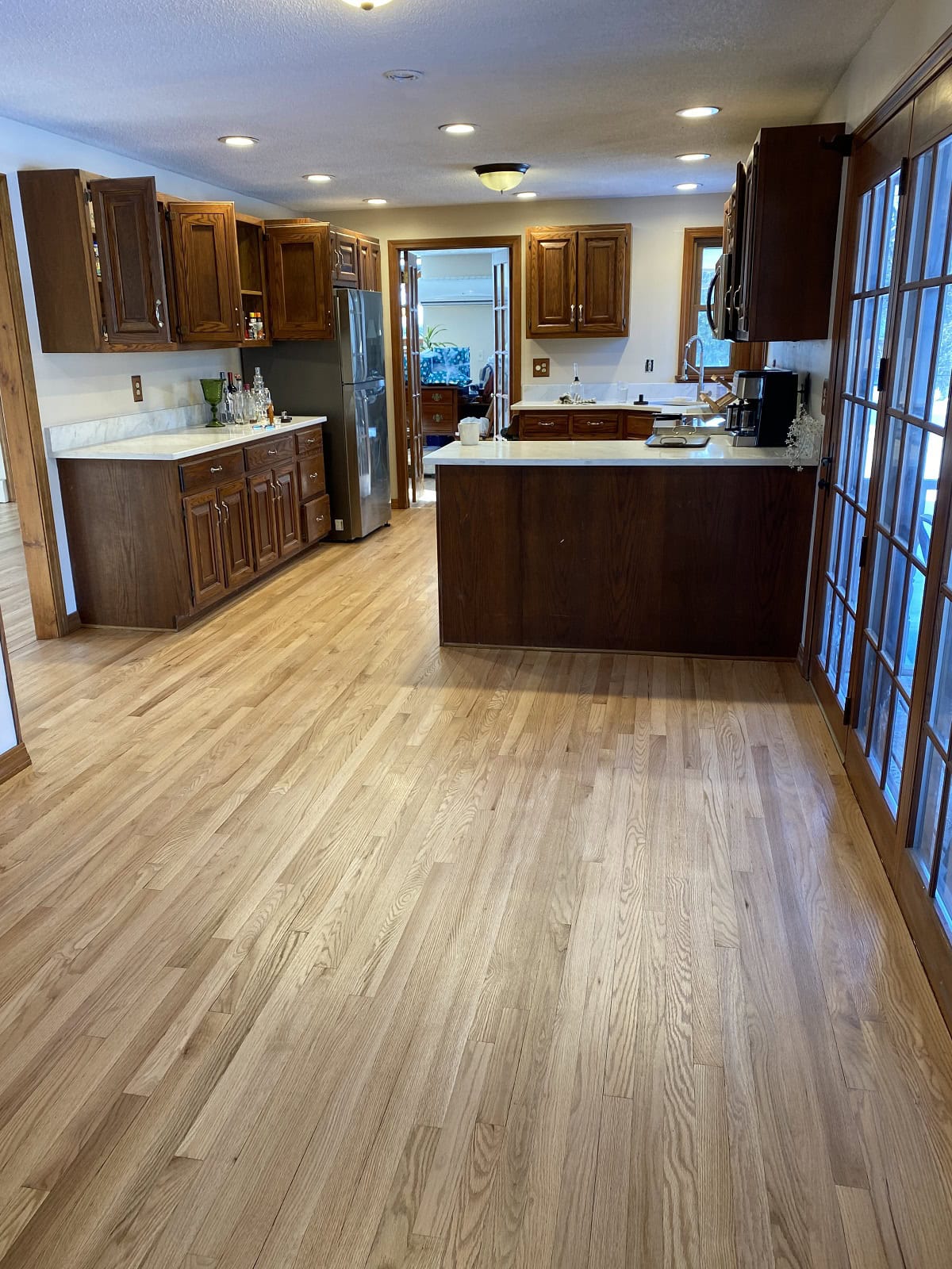Light oak hardwood flooring in a Bolton kitchen with natural wood grain, open layout, and seamless finish extending through cabinetry space