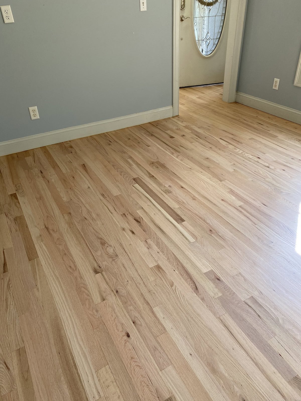 Light oak hardwood flooring in Tolland home entryway with clean finish, natural grain variation, and seamless transition between rooms
