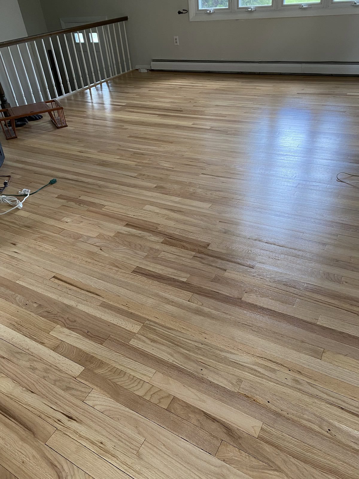 Vernon home with wide oak hardwood flooring in open living space featuring natural light and smooth satin finish