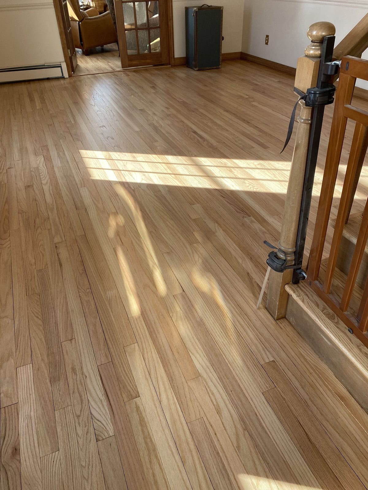 Warm oak hardwood flooring in a Bolton home with natural sunlight, smooth finish, and consistent wood grain across open living space