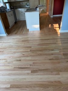 Refinished prefinished hardwood flooring transitioning into kitchen floor in Wethersfield Connecticut